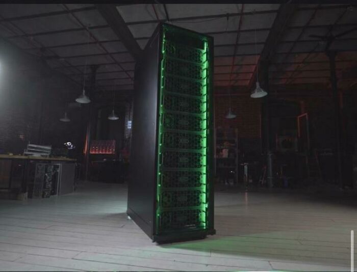 A tall, black server rack with glowing green lights inside, showcasing advanced technologies that make everyday life easier.