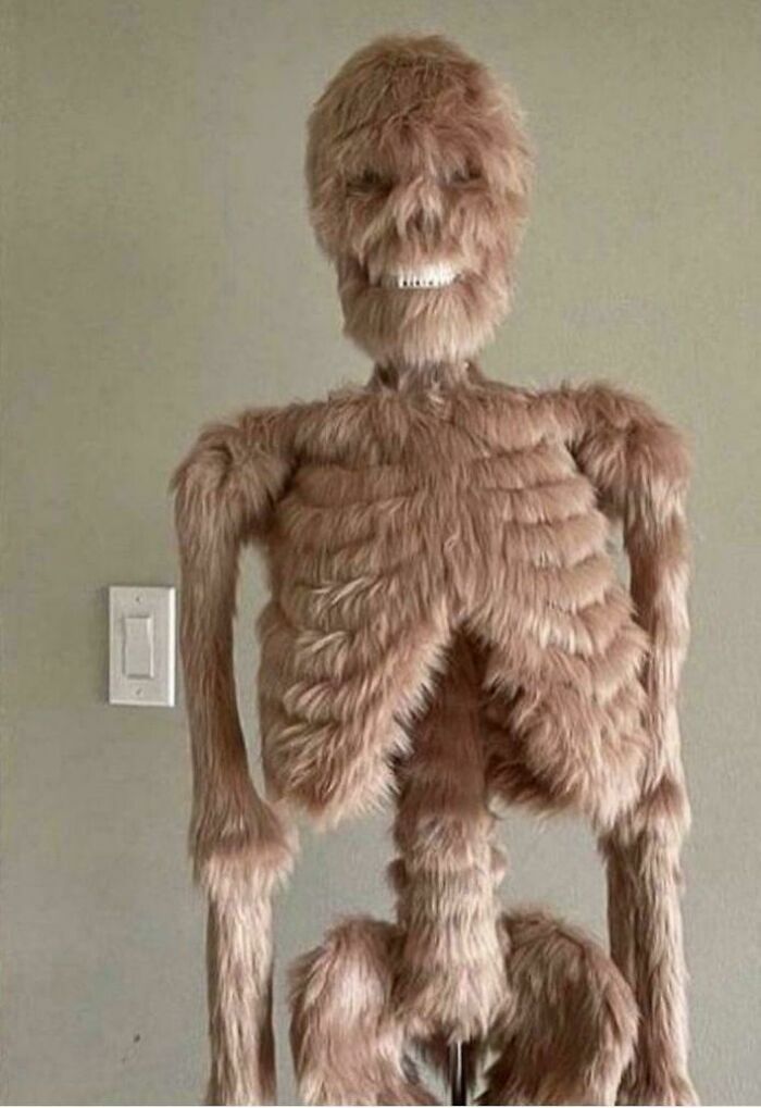 A full skeleton covered in light brown fur, standing upright, creating a creepy and confusing image.