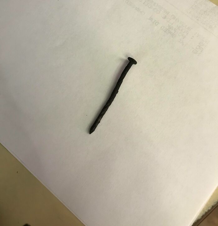 A single rusty, twisted nail on a white piece of paper, reflecting difficult situations for service industry workers.