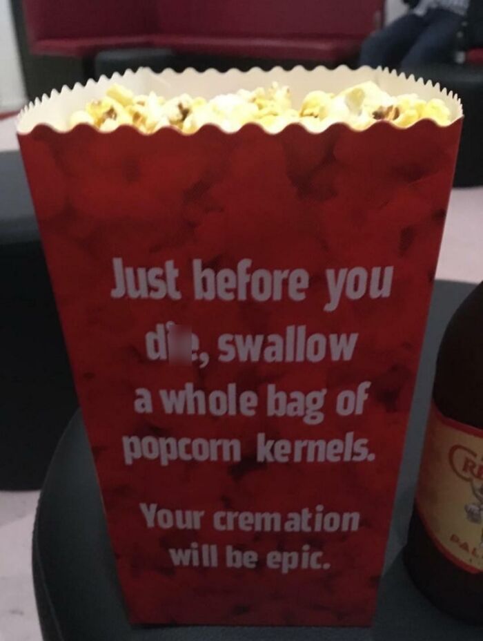 A red popcorn bag with a bizarre message about swallowing popcorn kernels before d***h for an epic cremation, an unfortunate display of stupidity.