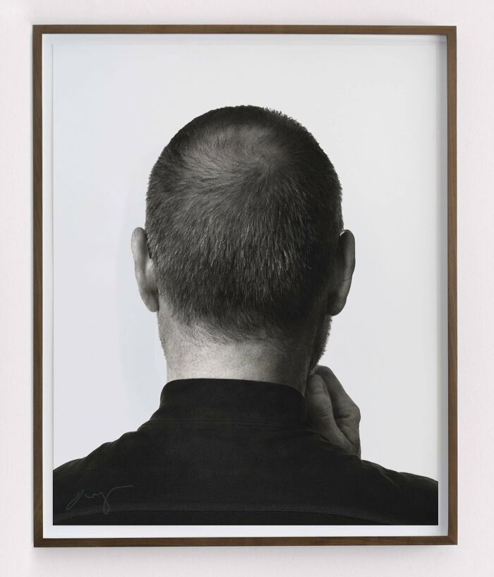 A fascinating masterpiece reimagined: a black and white image of a man's head from behind, with his hand touching his neck.