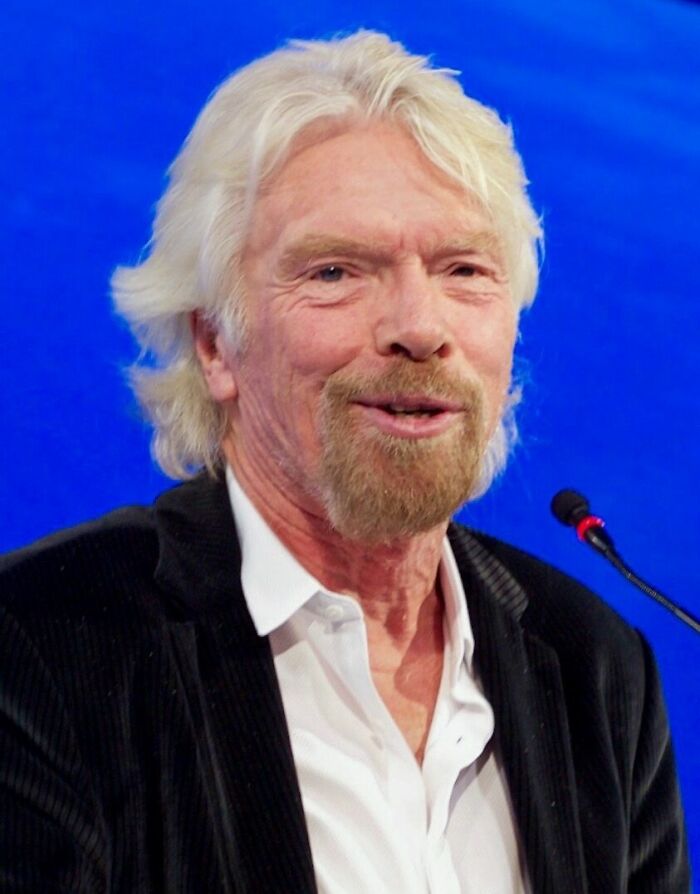 A close-up of Richard Branson smiling, featuring his bio and career highlights.