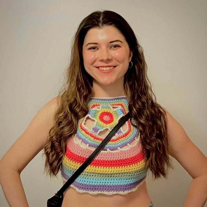 Smiling woman in colorful striped crochet crop top creative crochet project