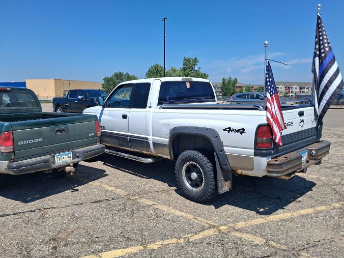 White Dodge truck with flags, displaying a unique perspective of chaotic good.