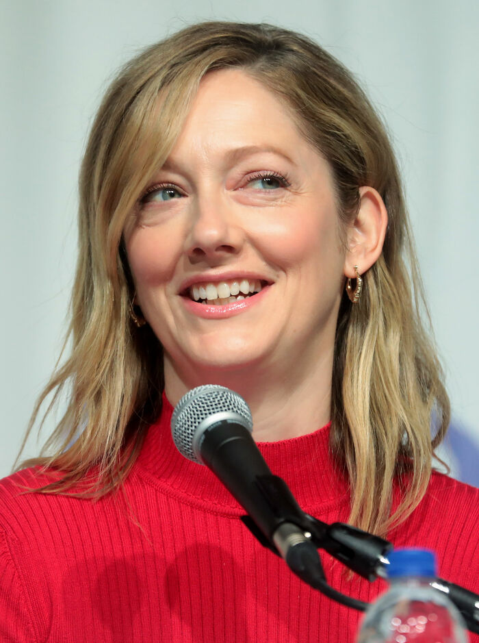 Actress Judy Greer smiling brightly while speaking into a microphone, highlighting her career.
