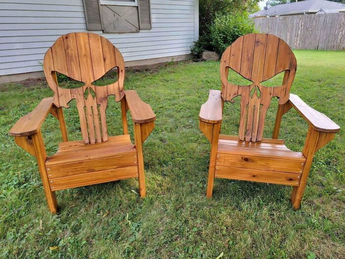 Two wooden chairs with skull-shaped backs, an example of bizarre furniture design.