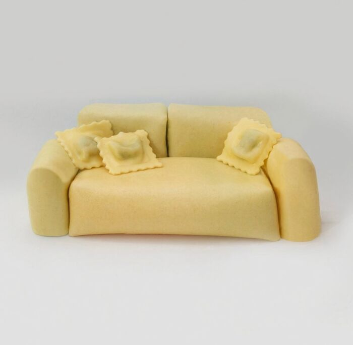 A miniature couch made of pasta with ravioli cushions, highlighting bizarre furniture design.