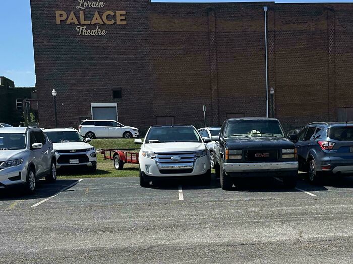 Outrageous parking of a white car occupying two spots in front of Lorain Palace Theatre.
