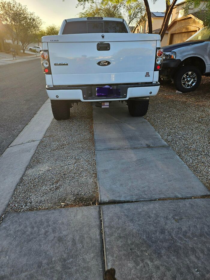 A white Ford pickup truck blocking a sidewalk, displaying outrageous parking.