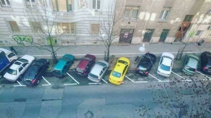 An aerial view of a street with several cars parked at odd angles, demonstrating outrageous parking.