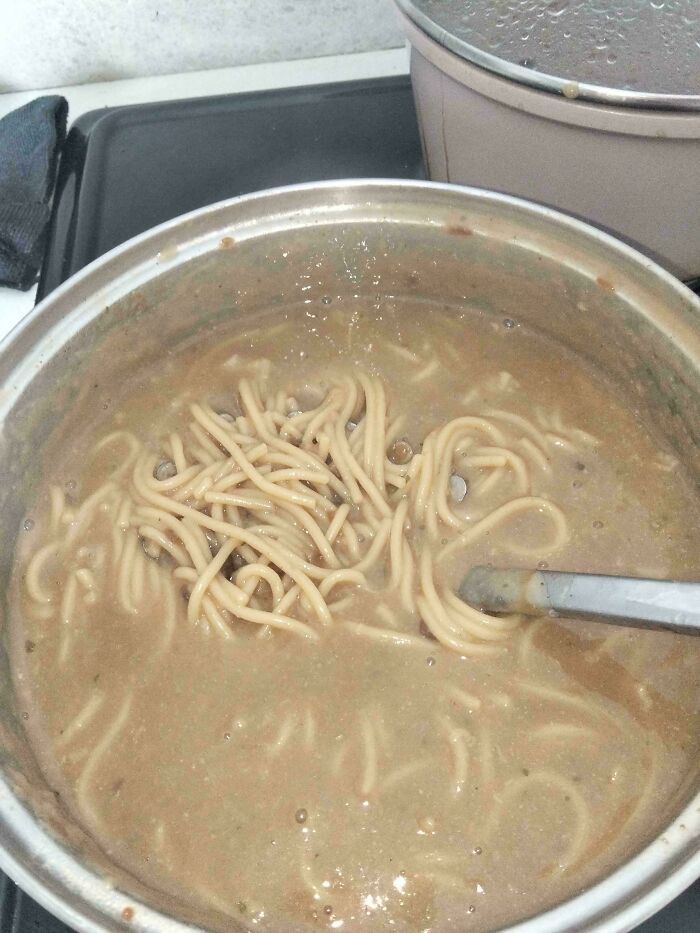 Stupid food: A pot of bland-looking spaghetti in a thick, unappetizing sauce being stirred.