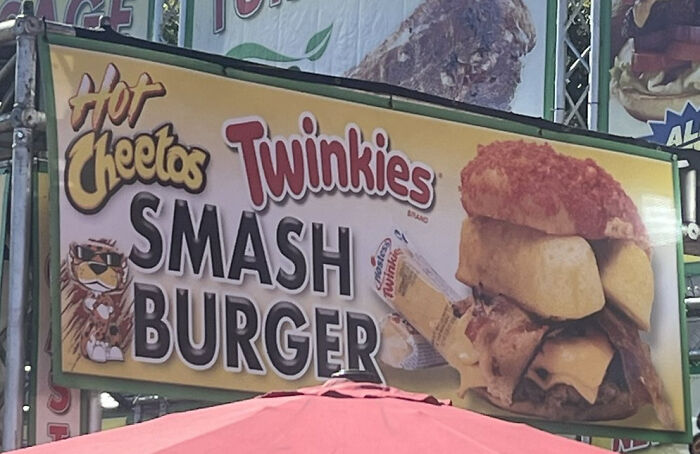 A sign advertising a Hot Cheetos Twinkies Smash Burger, a truly disgusting food combination.