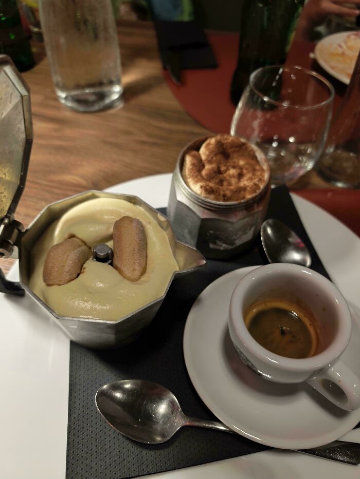 A dessert serving with a small espresso cup, a metal server with creamy dessert and cookies, and another small dish. Disgusting food choice.