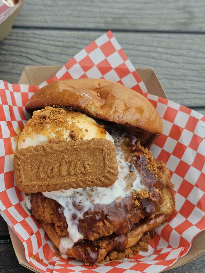 A close-up of disgusting food, a sweet fried chicken sandwich with ice cream, cookie, and syrup.