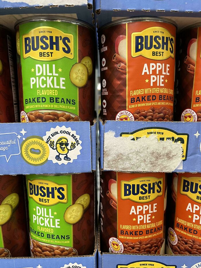 Cans of Bush's Best Dill Pickle and Apple Pie flavored baked beans on a store shelf. Stupid and disgusting food.