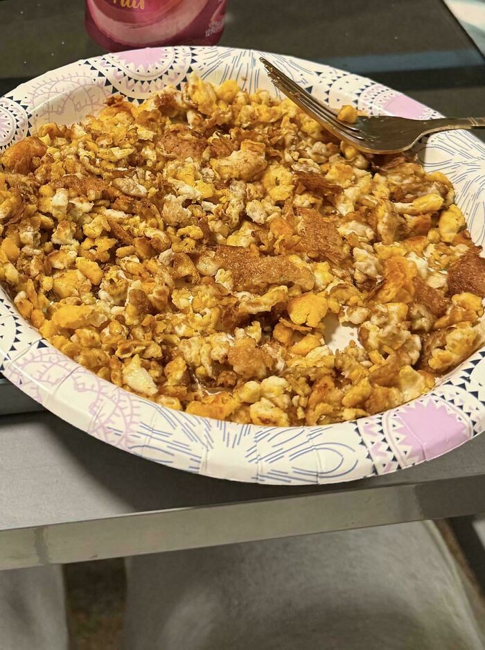 A paper plate filled with overcooked, crispy scrambled eggs, an example of disgusting food.