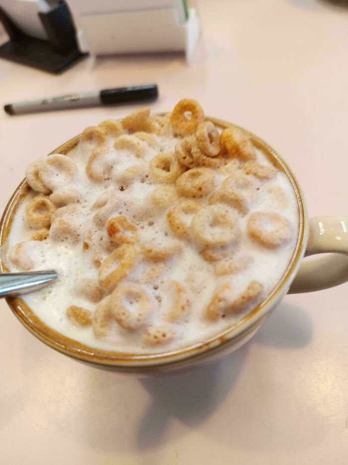 A close-up of a cup filled with cereal and milk, showing disgusting food.