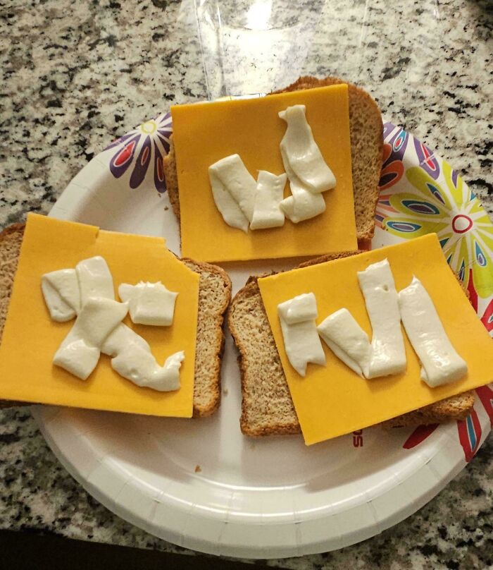 Three slices of bread with processed cheese slices and strange white dollops, representing stupid food.