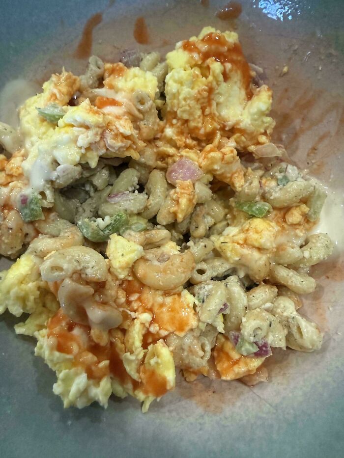 Disgusting food with a messy mix of pasta, scrambled eggs, and sauce, appearing unappetizing.