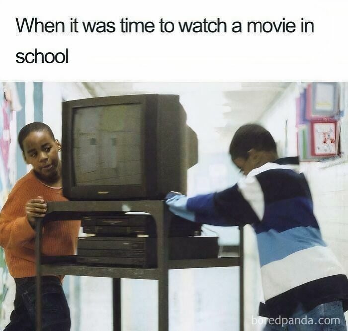 Students wheeling a TV/VCR cart in a hallway, bringing back memories of life in the 90s.