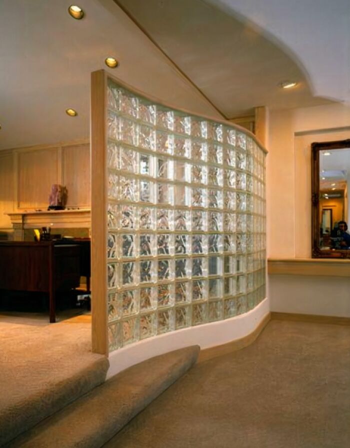 A curved glass block wall in an office setting, a common design element that might make you feel like you went through a time machine to the 90s.