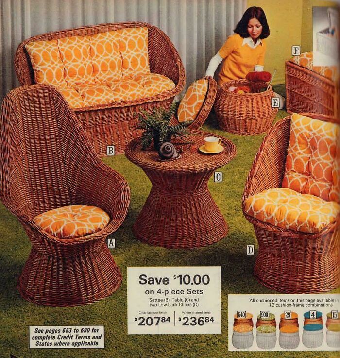 A set of wicker furniture with orange patterned cushions, including chairs and a table, in a classic 1970s and 1980s interior design style.