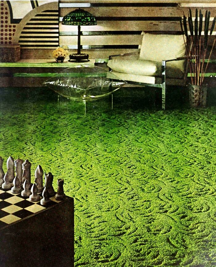 A vibrant green s**g carpet with a swirling pattern, a clear coffee table, and a modern chair, reflecting 1970s and 1980s interior design trends.