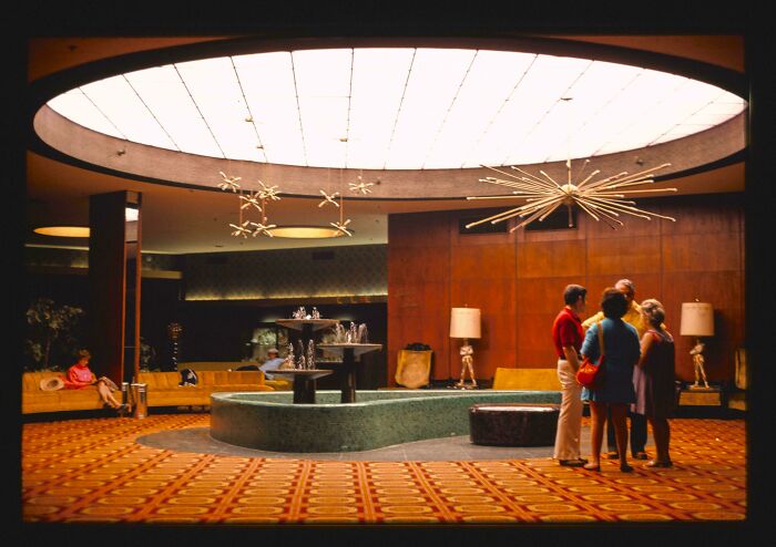 A hotel lobby from the 1970s and 1980s, showcasing interior design with a central fountain and stylish seating.