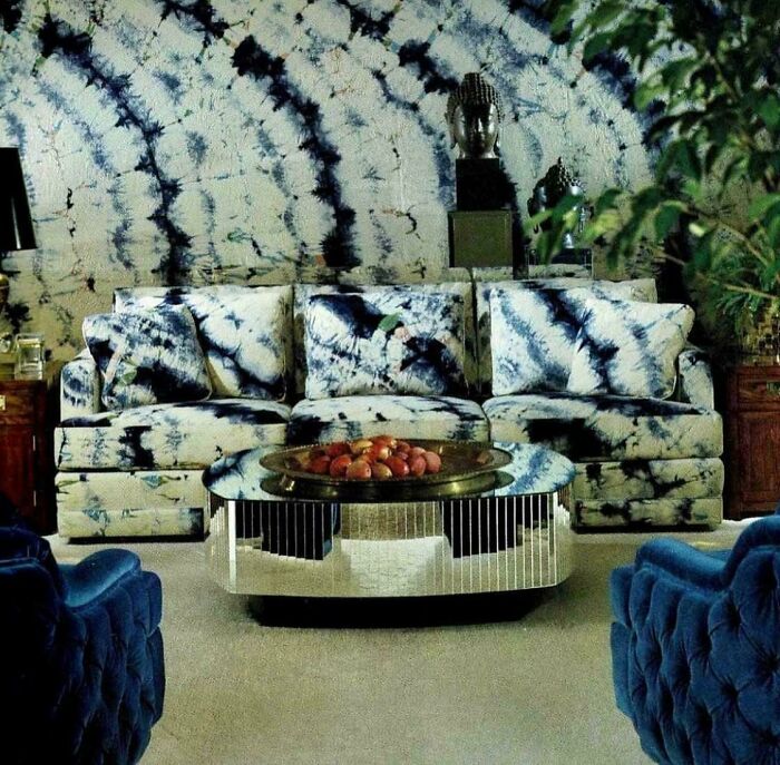 A living room with tie-dye patterns on walls and sofa, showcasing bold 1970s and 1980s interior design.