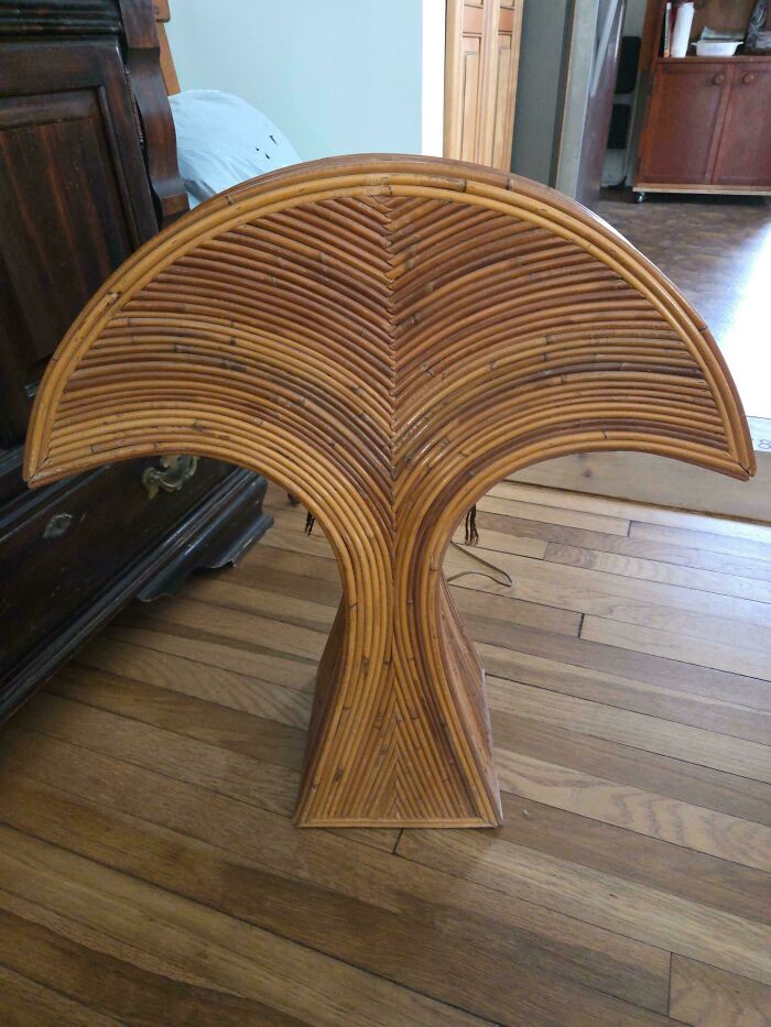 A unique fan-shaped rattan table, showcasing 1970s and 1980s interior design.
