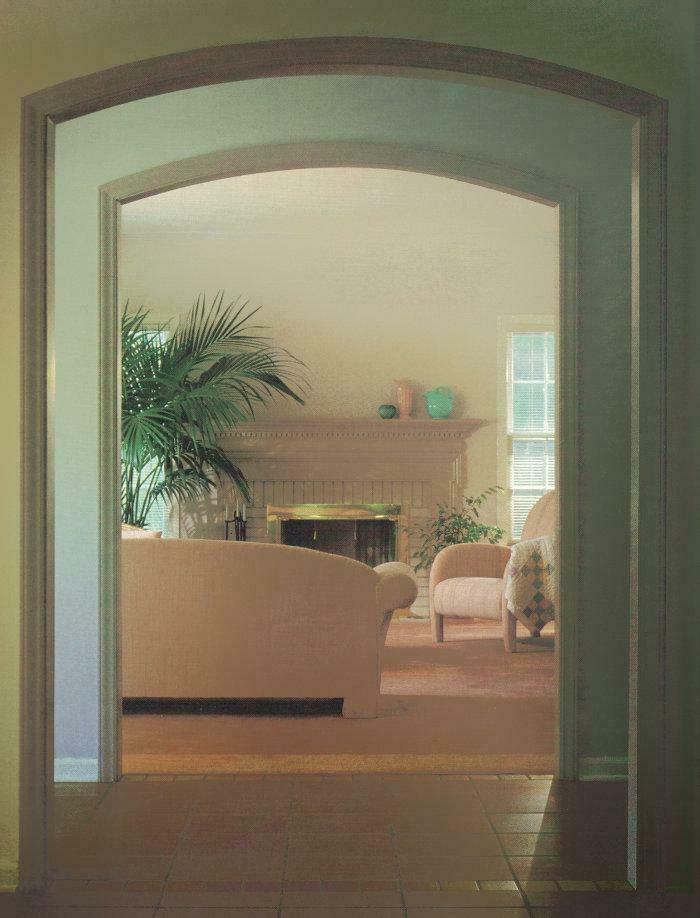 Living room entryway with an arched doorway, revealing subtle 1970s and 1980s interior design elements.