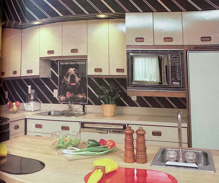 Vibrant kitchen showcasing 1970s and 1980s interior design with striped wallpaper and a full cooking space.