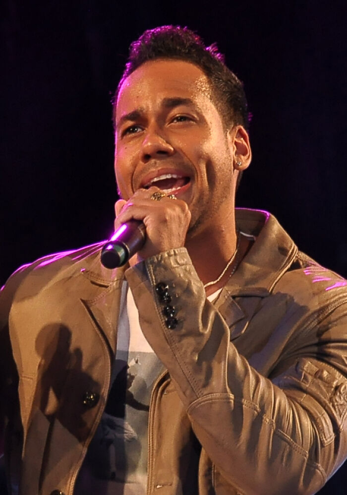 Romeo Santos performing live, a highlight of his music career, captured in an engaging close-up.
