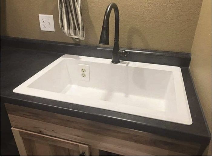 A sink with an electrical outlet inside, showcasing a dangerous construction fail.