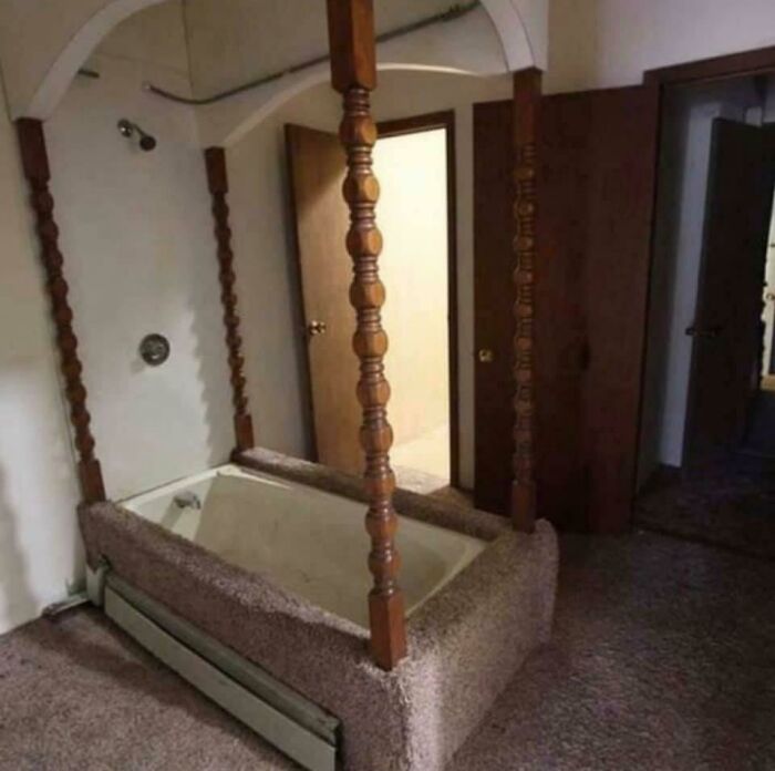 A bathroom with a bathtub covered in brown carpet and wooden posts, illustrating construction fails.