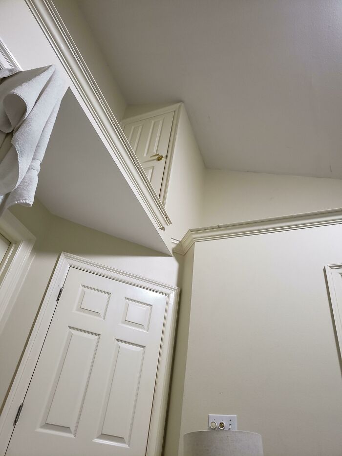 Multiple doors and a high, inaccessible cupboard creating a confusing space, showing construction fails in design.