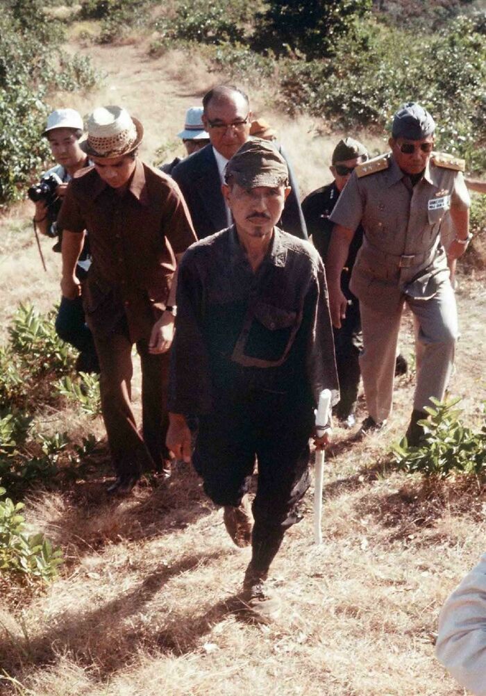 Historical photo of a Japanese soldier, Hiroo Onoda, emerging from the jungle, representing a forgotten past.