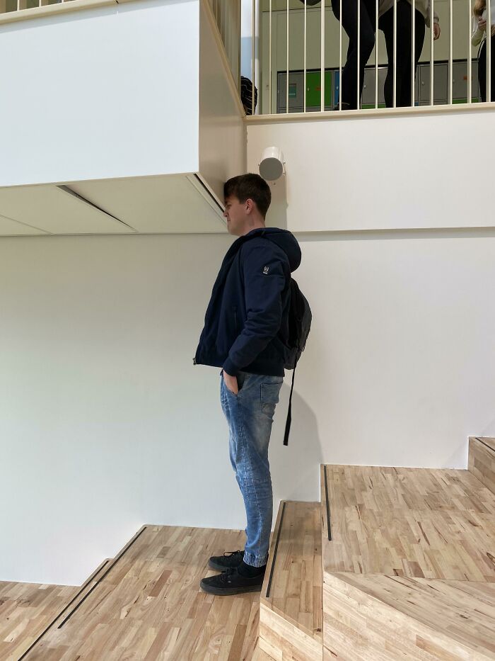 A construction fail where a man's head hits an overhang above a wooden staircase.