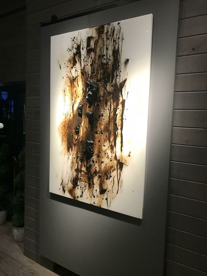 Abstract painting with brown and black streaks, highlighted by spotlights, a construction fail.