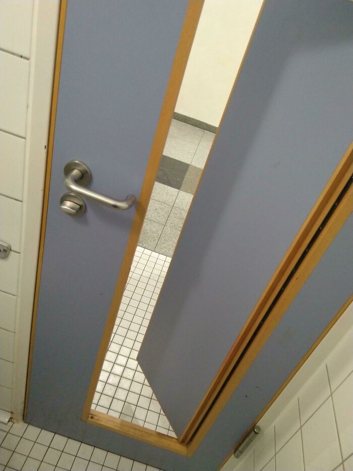A poorly installed door with a large gap at the bottom, revealing a construction fail.