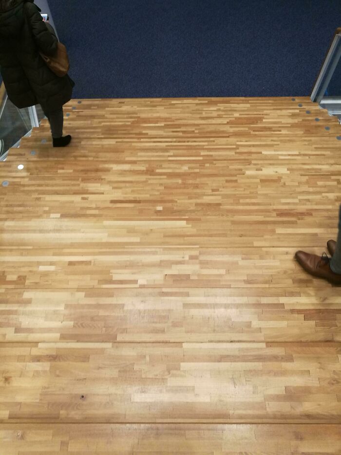 A seemingly flat wooden floor, actually stairs, representing a subtle construction fail.