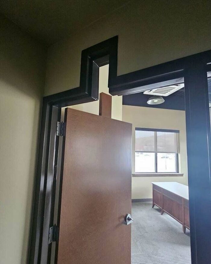 A poorly installed doorframe showing a significant construction fail, with a large gap above the door.