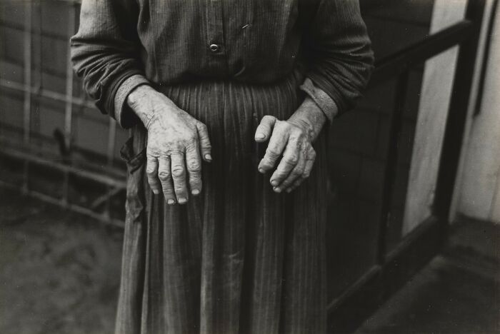 A historical photo focusing on the hands of an elderly person, showing visible signs of aging and possibly arthritis.