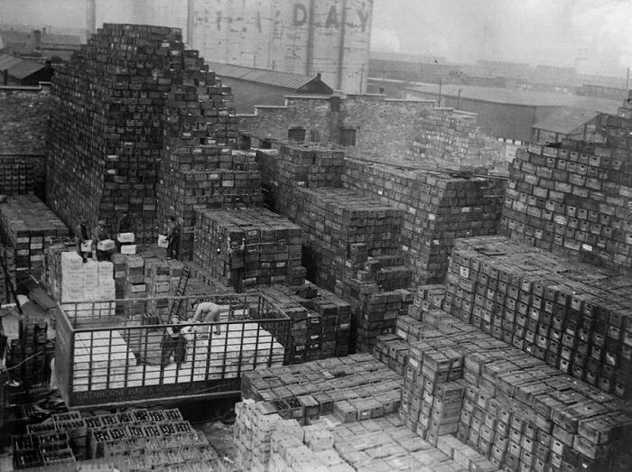 A historical photo capturing a vast outdoor storage area filled with stacks of crates, illustrating a past industry.