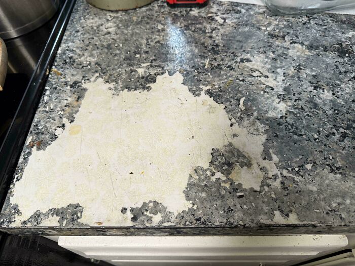 Image of a peeling countertop with a damaged surface. People ask for help fixing things.