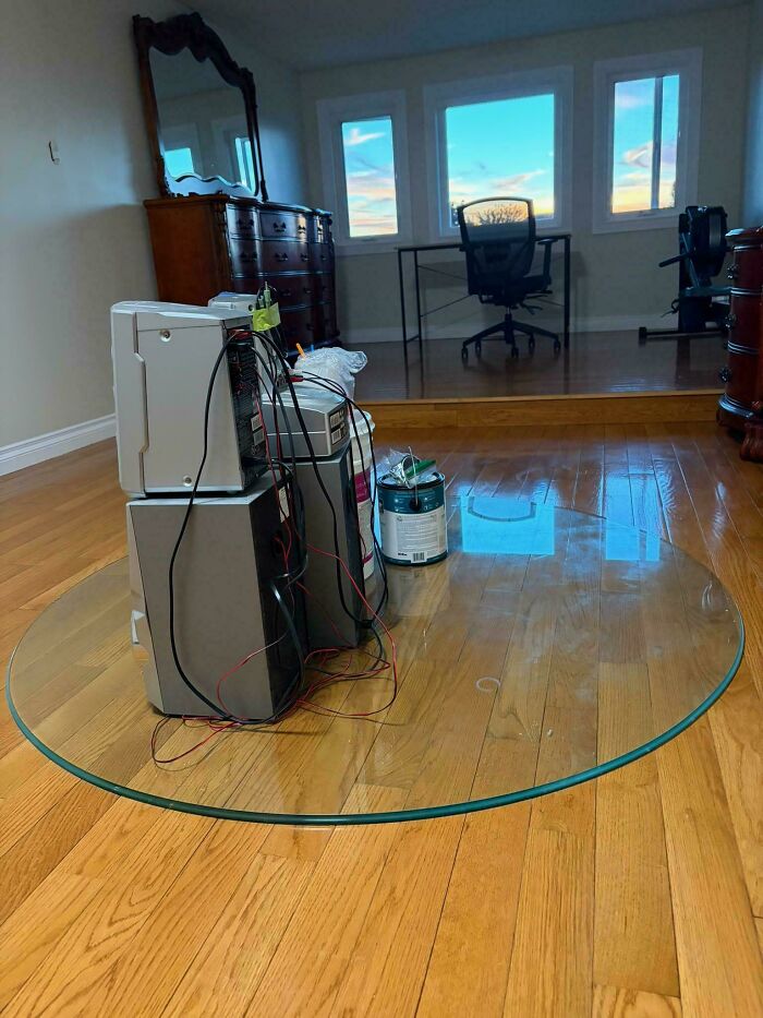 A makeshift computer setup on a glass table, illustrating people asking for help fixing things in home offices.