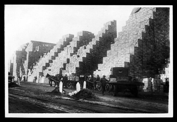 Historical photos of workers and horse-drawn carts next to enormous stacks of timber.
