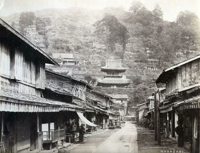 Historical photos: A street scene in Nagasaki with traditional buildings and a temple on a hillside, showing a past that will remain alive.