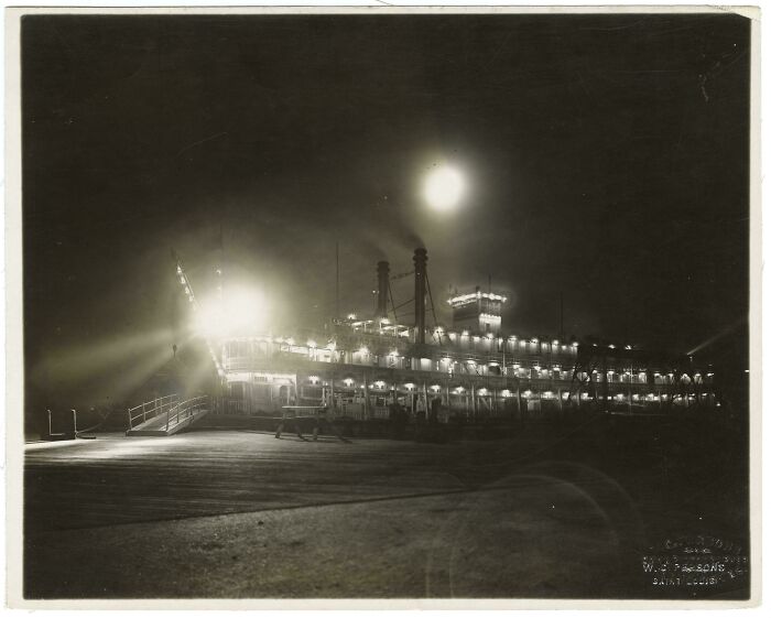Historical photos: A brightly lit paddle steamer at night, reflecting on the water, showing a past that will remain alive.