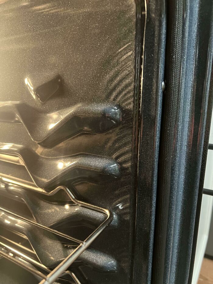 People ask others for help fixing a damaged oven door interior with racks visible.